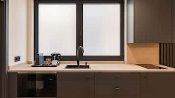 A modern kitchen with a double sink, a coffee maker, and a microwave.