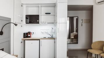 Une petite cuisine équipée d’un four à micro-ondes, d’un petit réfrigérateur et d’un évier.