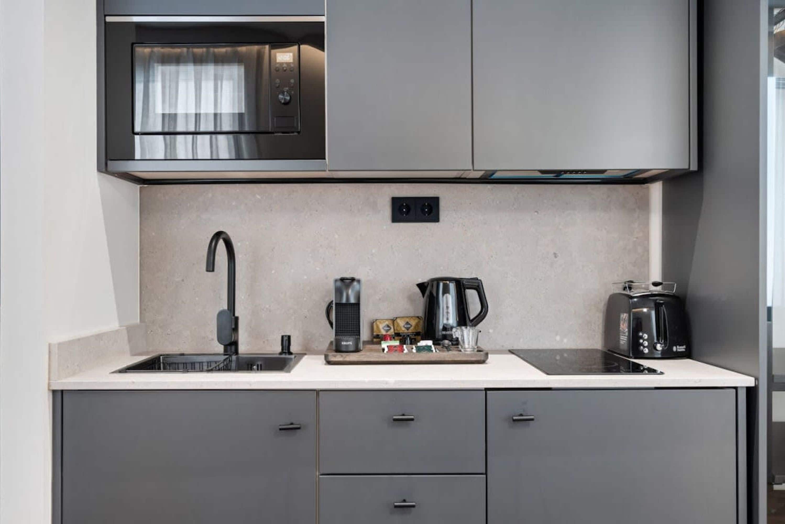 A modern kitchen with a built-in microwave, a coffee maker, and a toaster.