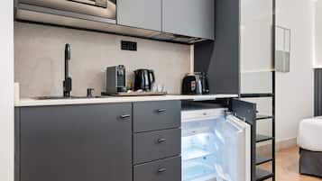 A modern kitchen with a built-in microwave, coffee maker, and a refrigerator with a water dispenser.