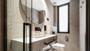 A modern bathroom with a large mirror, a toilet, and a sink. - Pacifico Deluxe Double Suite Near Retiro (Madrid)