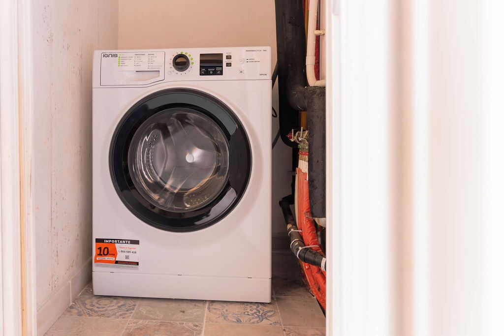 Een compacte, witte wasmachine met voorlader, bedieningspaneel en een label met de prijs 10.