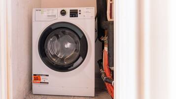 Een compacte, witte wasmachine met voorlader, bedieningspaneel en een label met de prijs 10.