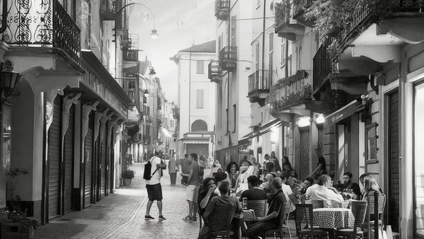 A cobblestone street lined with buildings, some with balconies and outdoor seating areas. - Beautiful spacious flat in the old town of Ivrea (Ivrea)