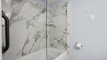 Regadera, secadora de cabello, toallas, papel de baño