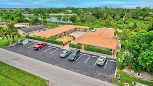 A motel with multiple parking spaces and a covered parking area. - Paradise Inn of Naples (Naples)