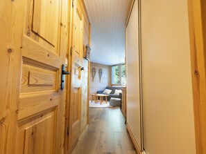 A wooden interior hallway with a dining area at the end, featuring a table and chairs. - Val Snow 210 Cosy and Practical Apartment in the Heart of Val d’Isère (Val-d'Isère)
