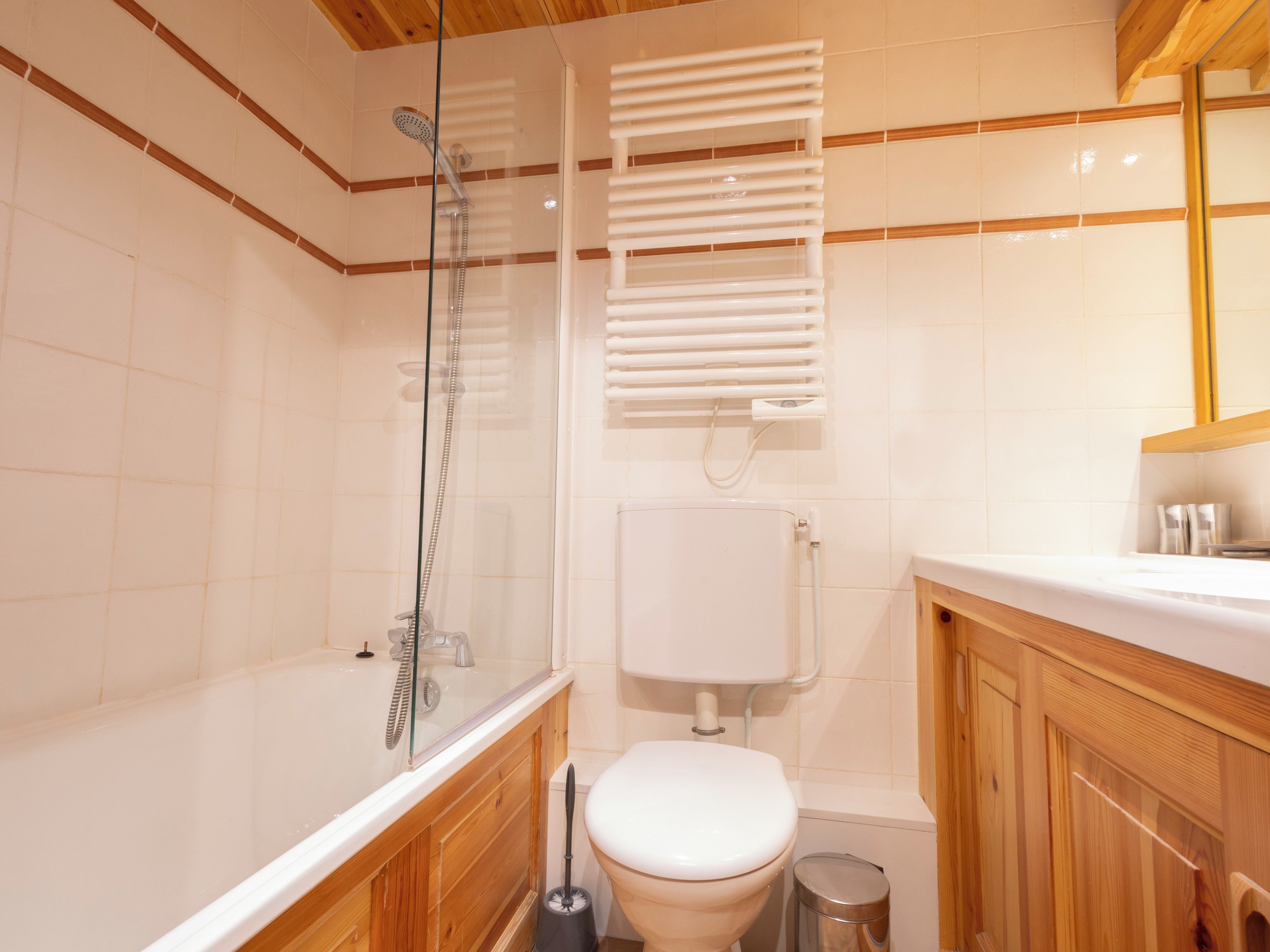 Een badkamer met een douche met glazen wand, een toilet en een wastafel.