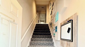 A staircase with patterned carpet leading to a landing. - Lee's Summit Loft-near downtown (Lee's Summit)