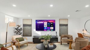 A modern living room with a flat-screen TV, comfortable seating, a fireplace, and a coffee table. - Modern 3BR • Near Downtown Boston • Walk to T • Minutes to Logan • Free Parking (Boston)