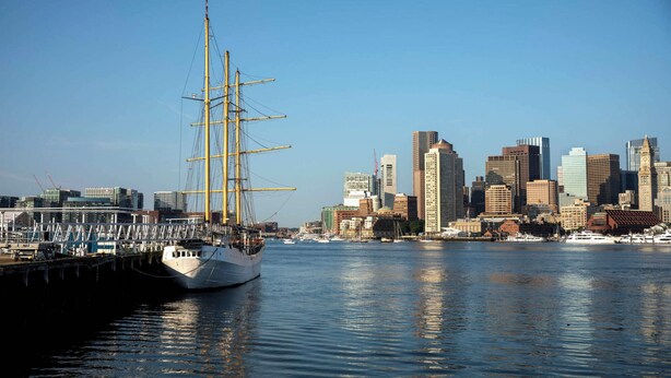 A tall ship docked at a harbor with a city skyline in the background. - Modern 3BR • Near Downtown Boston • Walk to T • Minutes to Logan • Free Parking (Boston)