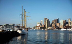 A tall ship docked at a harbor with a city skyline in the background. - Modern 3BR • Near Downtown Boston • Walk to T • Minutes to Logan • Free Parking (Boston)