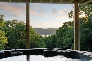 Ein Whirlpool mit Blick auf einen von Bäumen umgebenen See.