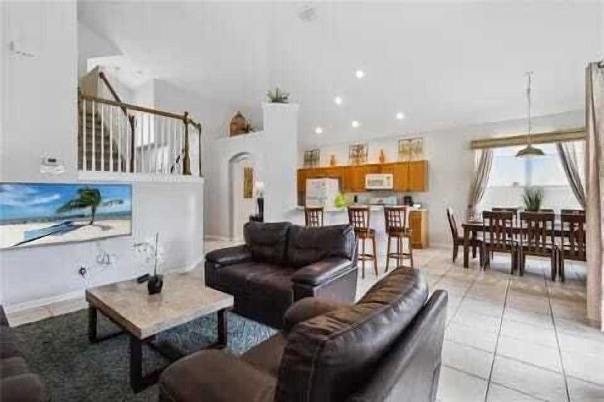 A spacious living area with a sofa, coffee table, and a painting of a beach scene.
