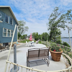 Eine Uferterrasse mit Außenbestuhlung, einer Fahnenstange und Blick auf den See.