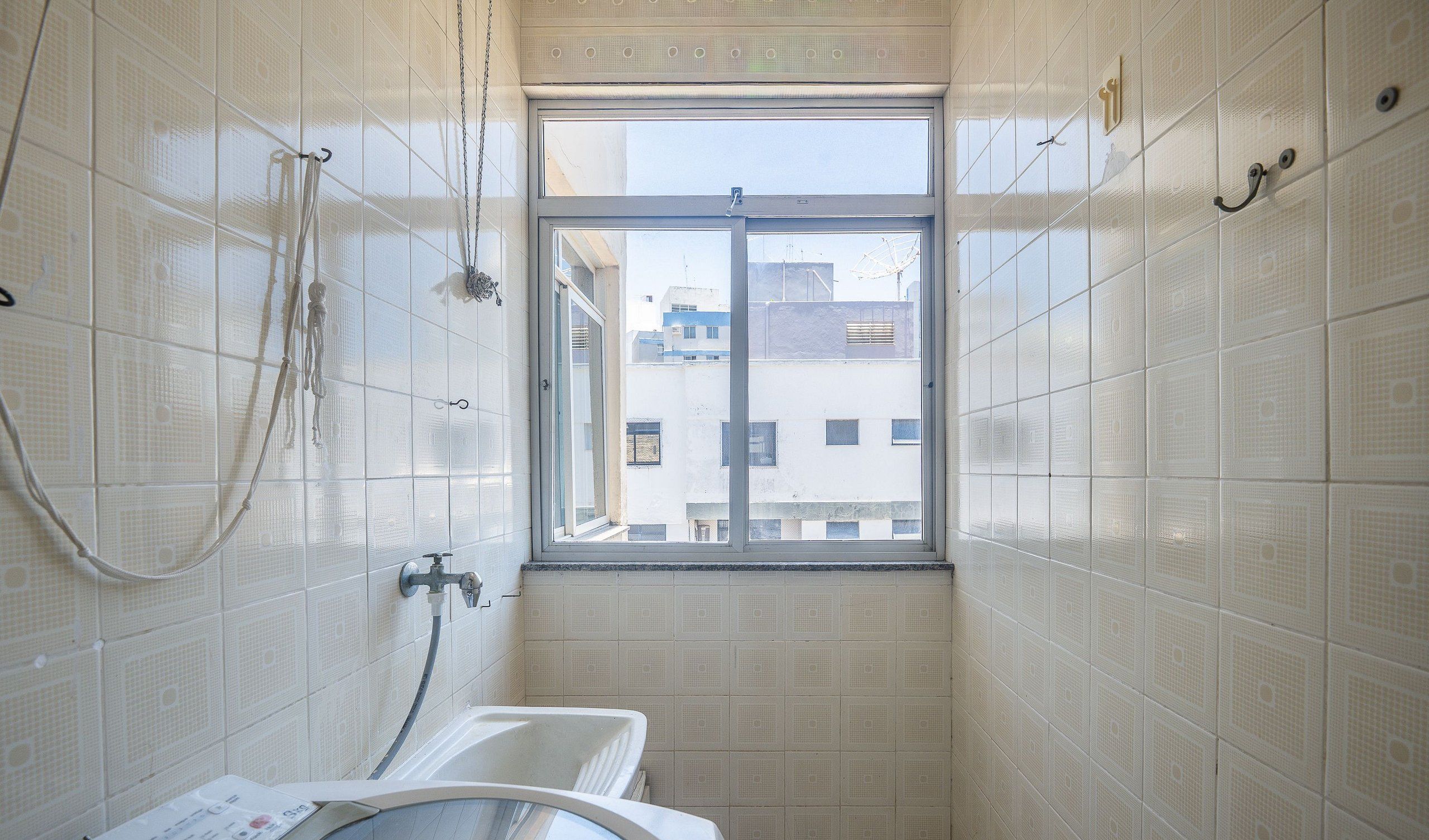 A small bathroom with a window, a bathtub, and a shower.