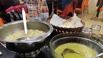 Una mesa de comedor con distintos platos, cubiertos y una botella de agua.