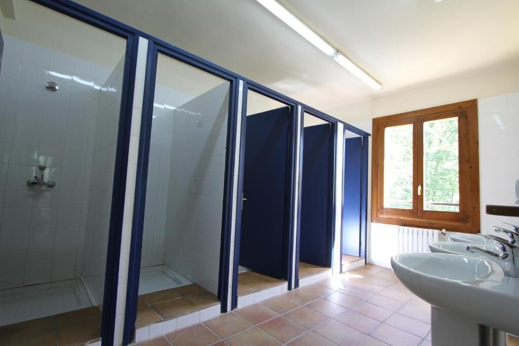 Un baño con ducha, lavamanos y ventana.