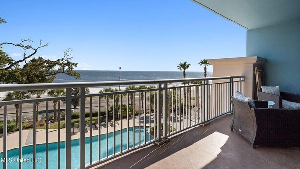Un balcone con vista su una piscina e sull'oceano.