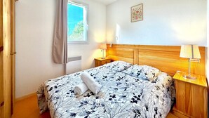 Ein Schlafzimmer mit Bett, Fenster, Klimaanlage, Lampe und Wanddeko.