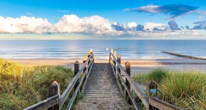 Single-storey beachlodge close to the sea, with fenced terrace and awning.