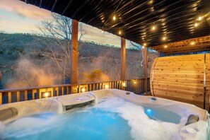 A hot tub with a wooden deck and a view of a forested hillside. - New Build with Impeccable Design in Massanutten (Massanutten)