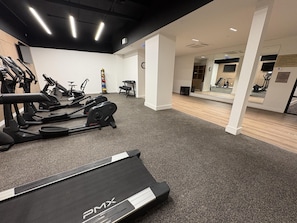 A gym with treadmills, stationary bikes, and a mirrored wall. - Aiden By Best Western Kansas City Downtown (Kansas City)