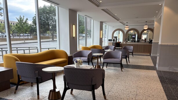 A modern interior with seating, a bar area, and large windows.