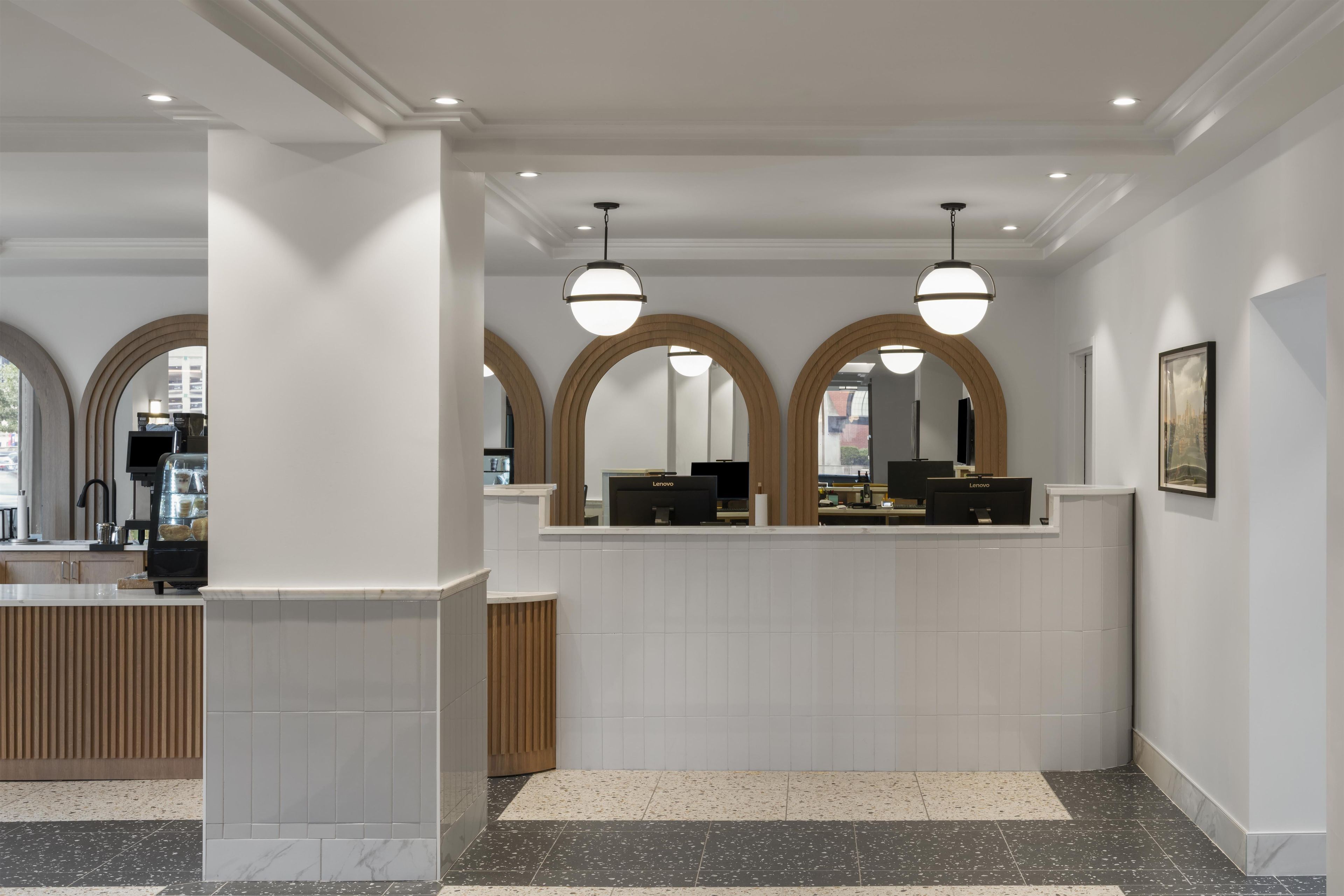 A reception area with a counter, multiple monitors, and a framed picture on the wall.
