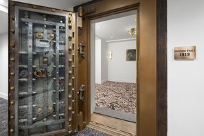 A room with a large, ornate safe door, a carpeted floor, and a sign indicating a historic vault from 1919. - Aiden By Best Western Kansas City Downtown (Kansas City)