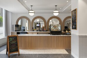 A modern cafe with a wooden counter, espresso machines, and a chalkboard menu. - Aiden By Best Western Kansas City Downtown (Kansas City)