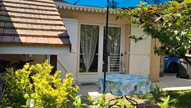 A house with a tiled roof, a covered patio, and a table with a tablecloth. - "Le Pesquit" large, fully-equipped 36m2 studio on one level: private terrace. (Lescar)