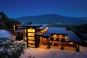 A modern house with a large deck, a swimming pool, and a view of mountains. - MODERN NEW CONSTRUCTION! Naturehaus Family Retreat–Pool, Golf, Pickleball, Views (Pigeon Forge)