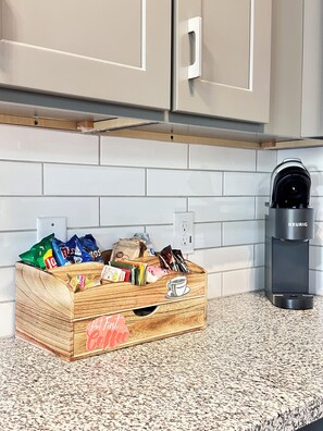 A kitchen with a wooden crate filled with coffee products, a Keurig coffee maker, and a white tiled backsplash. - 4 Bedroom / 4.5 Bathroom, Unit B_ Newly Built - Med Center / NRG / Downtown / UH (Houston)