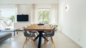 En matplats med ett träbord, sex stolar, en tv och utsikt över omgivningen.