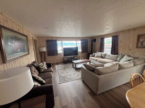 Ein gemütliches Wohnzimmer mit einer Couch, einem Couchtisch und einem Fernseher.