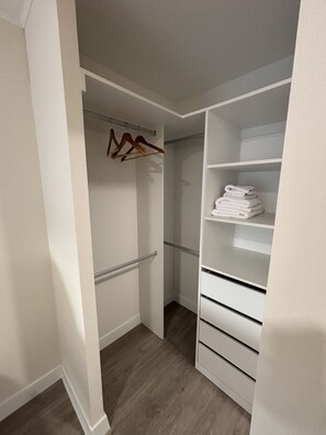 A walk-in closet with white shelves and drawers, a hanging rod, and neatly folded towels. - 2-bedroom apartment w/Pool in Miraflores close to Larcomar (Miraflores)