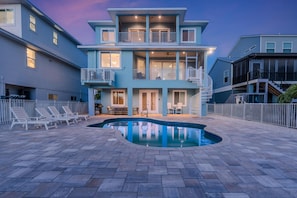 A multi-story residential building with a swimming pool and outdoor seating. - Beach Nuts (Fort Myers Beach)