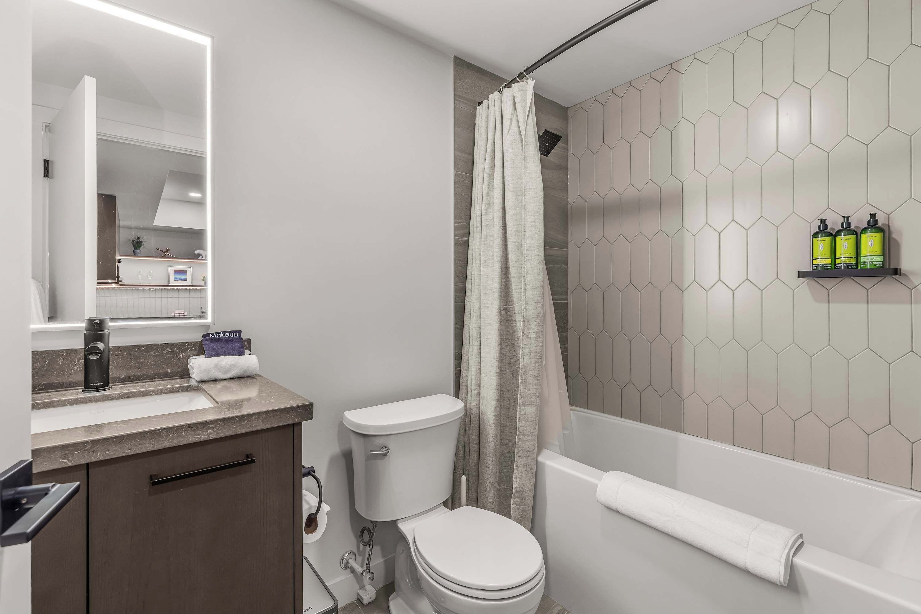 Une salle de bain moderne équipée de toilettes, d’un lavabo et d’un espace douche.