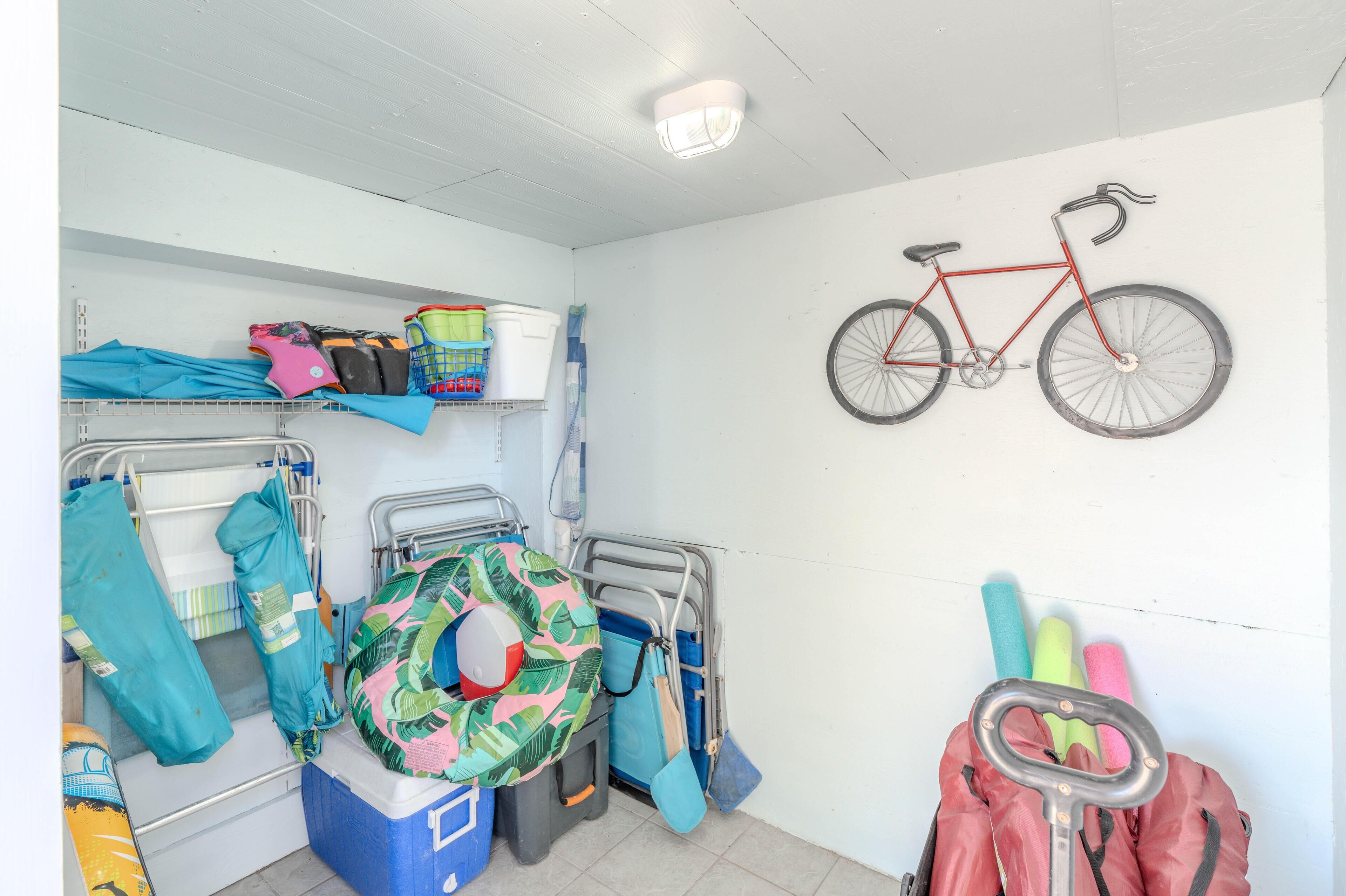 A dormitory room with bunk beds, a bicycle mounted on the wall, and various personal items and storage bins.