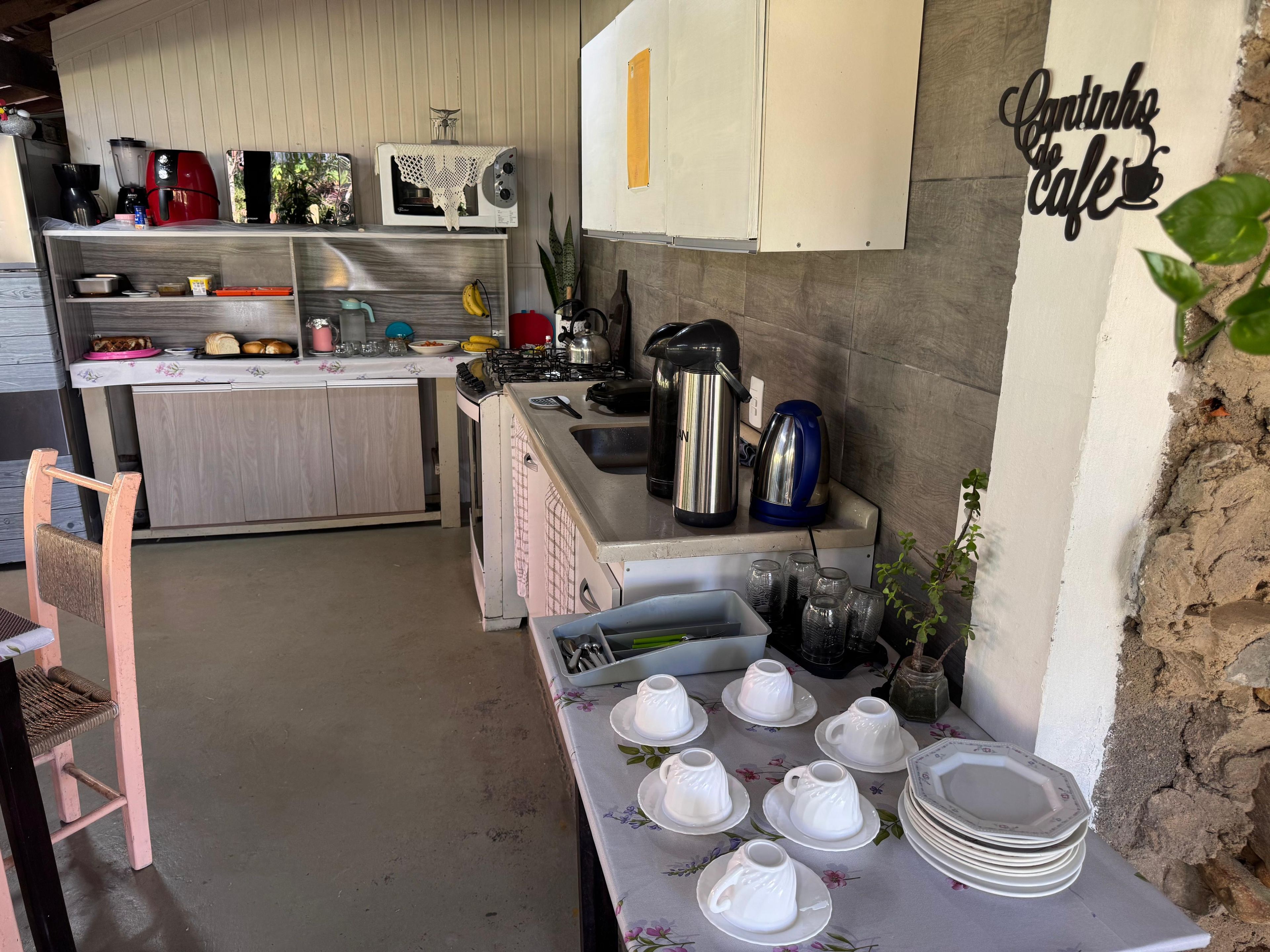 A kitchen with a coffee station, a microwave, and a stove.