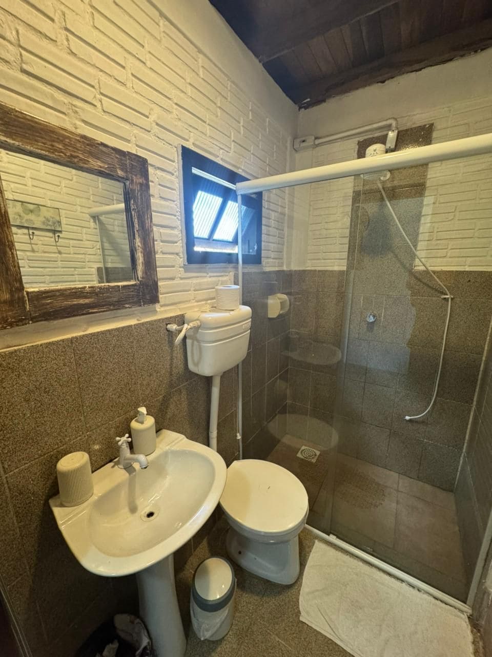A bathroom with a white sink, toilet, and a glass-enclosed shower area.
