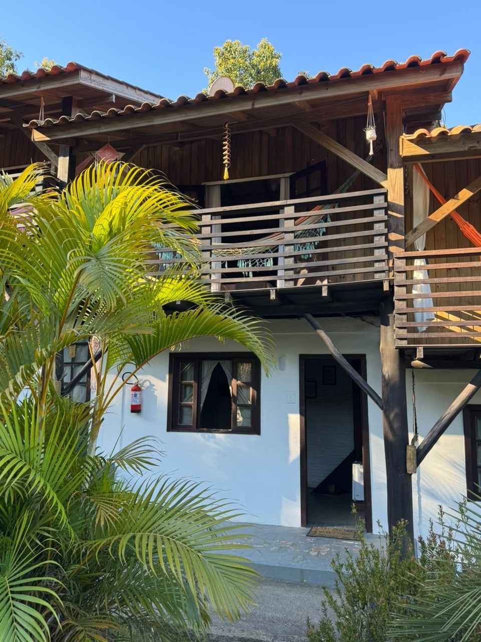 A two-story building with a wooden balcony and a white facade.