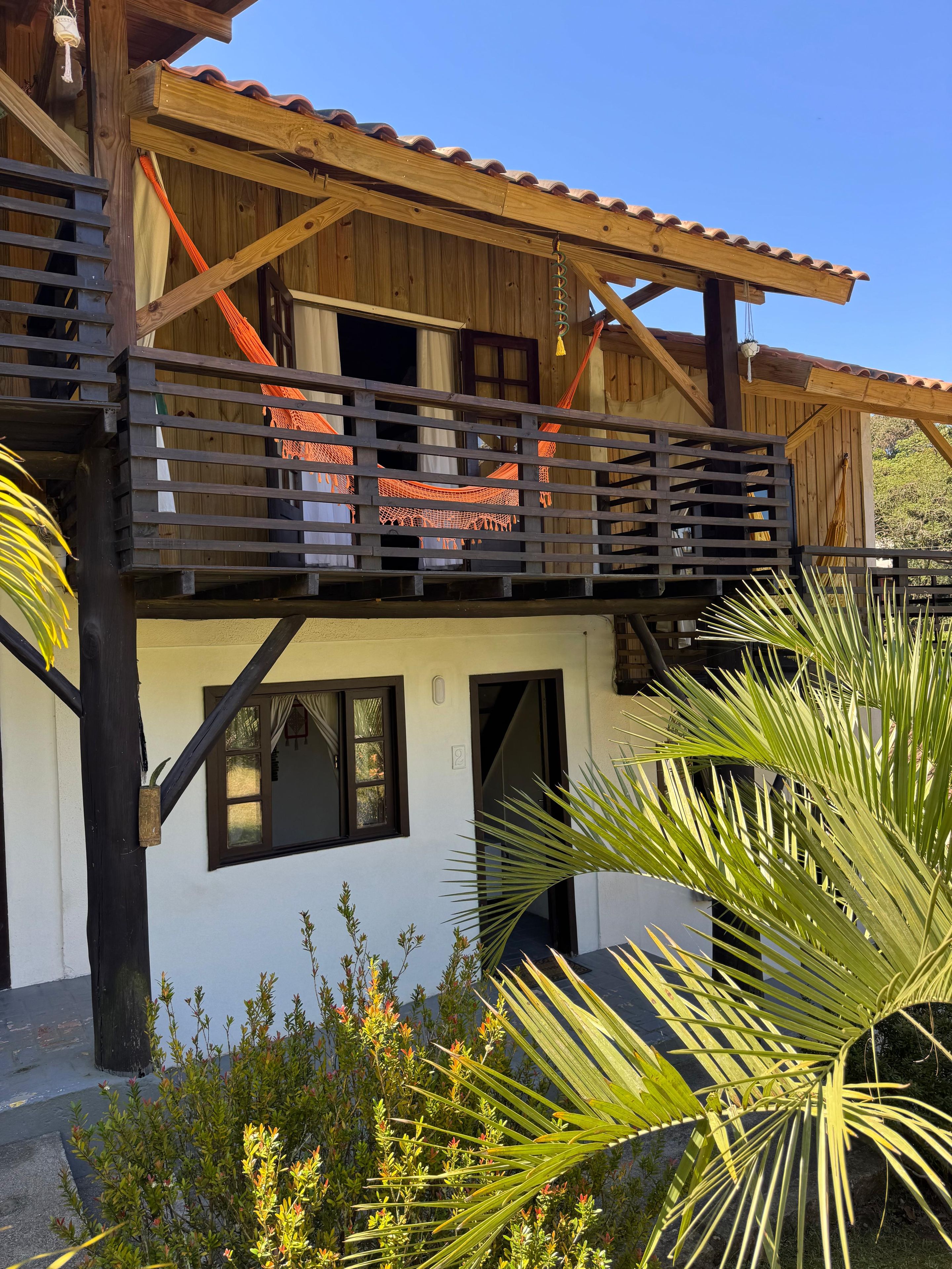 Un edificio de madera con un balcón, una ventana y una puerta.