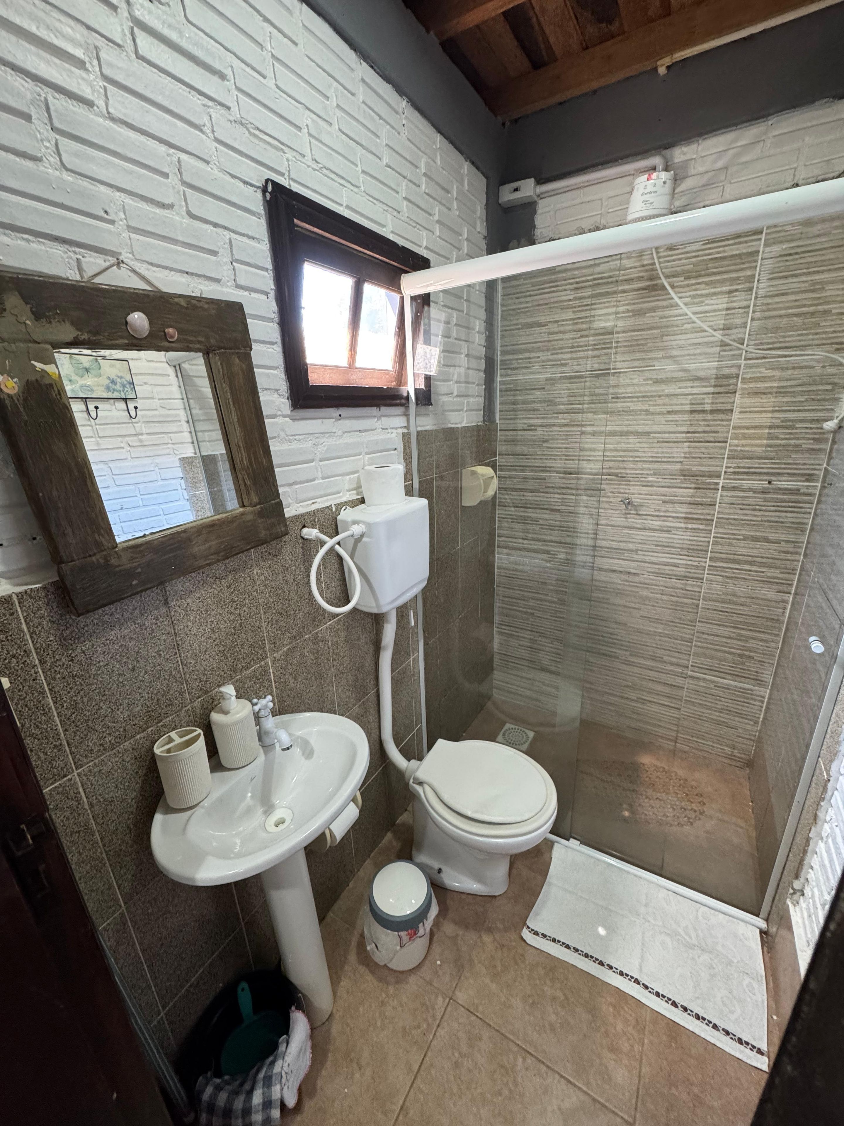 A bathroom with a white sink, toilet, and shower area.