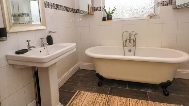Un baño con una bañera independiente, un lavabo y un espejo.