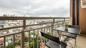 Un balcon avec vue sur la ville, une table et deux chaises.