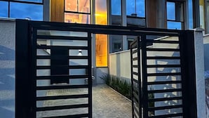 A modern building with large windows and a gated entrance. - Sobrado 03 (Florianópolis)