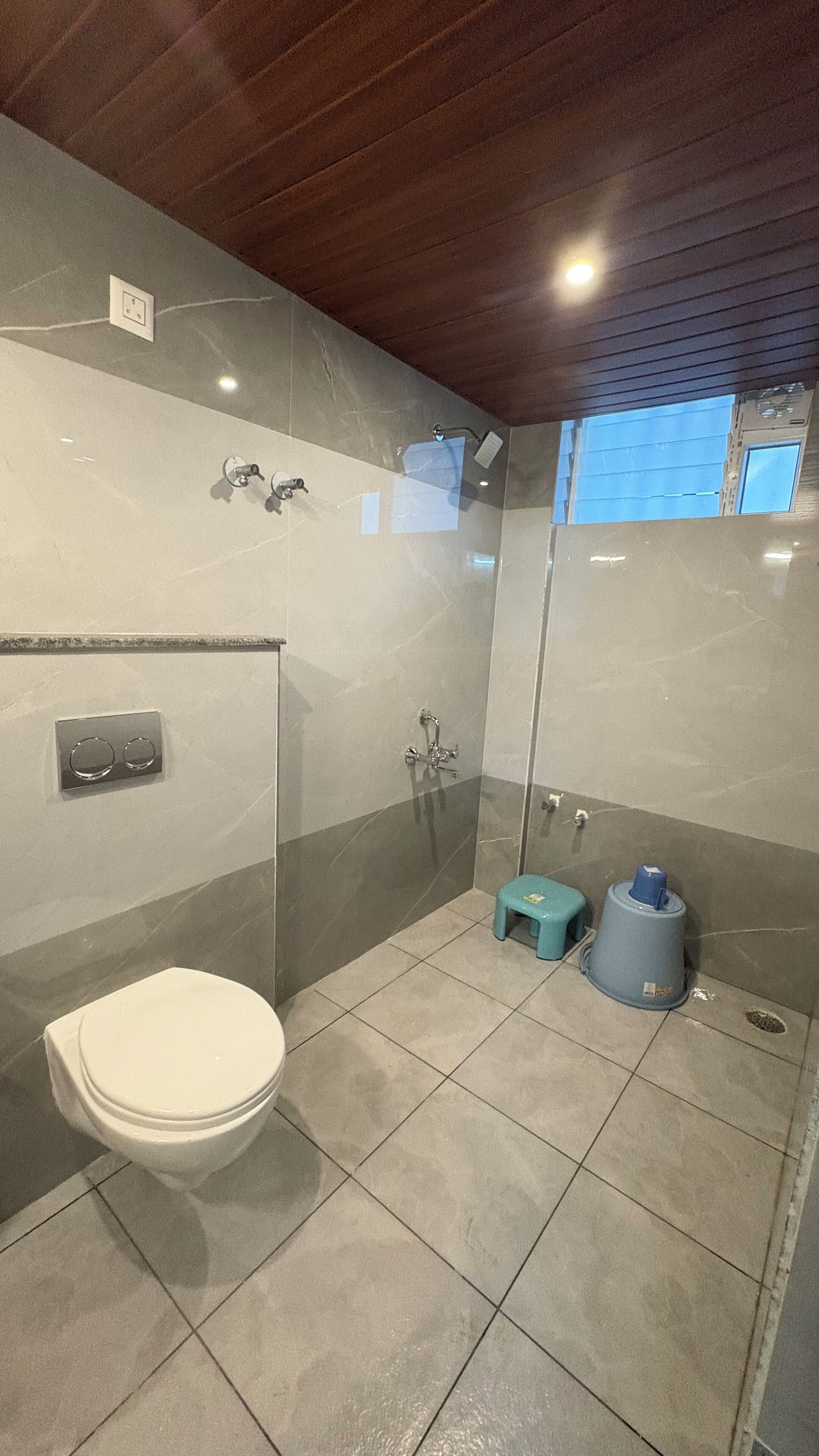 A bathroom with a toilet, a shower, and a sink.