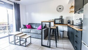 A modern living room with a grey sofa, a coffee table, and a TV stand. - "I Cavadilli" – Peaceful Studio | by Efficios (Propriano)